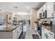 Open kitchen with granite island, pendant lighting, and stainless steel appliances at 9028 Forge Breeze Loop, Wesley Chapel, FL 33545