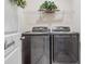 Well-equipped laundry room featuring modern gray washer and dryer units with a decorative shelf above at 9028 Forge Breeze Loop, Wesley Chapel, FL 33545
