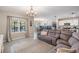Inviting living room showcasing an open-concept layout with a gray sectional sofa and tile flooring at 9028 Forge Breeze Loop, Wesley Chapel, FL 33545