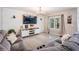 Cozy living room showcasing a large sectional sofa, entertainment center, and ample natural light at 9028 Forge Breeze Loop, Wesley Chapel, FL 33545