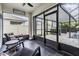 Covered patio with black tile floor, seating, and beautiful views of the screened-in pool at 9028 Forge Breeze Loop, Wesley Chapel, FL 33545