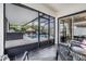 Covered patio featuring outdoor seating area, black tile floor, and pool views at 9028 Forge Breeze Loop, Wesley Chapel, FL 33545