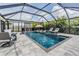 Inviting screened-in pool with sun loungers, seating area, and outdoor kitchen at 9028 Forge Breeze Loop, Wesley Chapel, FL 33545
