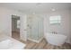 Bright bathroom featuring a walk-in glass shower and free-standing tub at 10036 Surrey Rose Dr, San Antonio, FL 33576