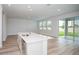 The open floor plan showcases a kitchen with an island and connects to a spacious living room and backyard access at 10036 Surrey Rose Dr, San Antonio, FL 33576