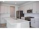 Modern kitchen with stainless steel appliances, gray cabinets, quartz countertop island and light wood-look floors at 10036 Surrey Rose Dr, San Antonio, FL 33576