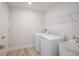 Functional laundry room equipped with a sink, modern machines, and shelving at 10036 Surrey Rose Dr, San Antonio, FL 33576