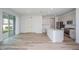 Open concept living room and kitchen area with light hardwood floors, stainless steel appliances, and a sliding glass door at 10036 Surrey Rose Dr, San Antonio, FL 33576