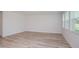 Bright, open room showcasing wood-look floors and plenty of natural light from a set of windows on the far wall at 10036 Surrey Rose Dr, San Antonio, FL 33576