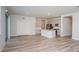 Open concept living room and kitchen area with light hardwood floors and stainless steel appliances at 10036 Surrey Rose Dr, San Antonio, FL 33576