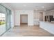 Open concept living room and kitchen area with light hardwood floors, stainless steel appliances, and a sliding glass door at 10036 Surrey Rose Dr, San Antonio, FL 33576