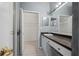 Well-lit bathroom with a walk-in closet, modern vanity, dark countertops, and a sleek white sink at 1050 Starkey Rd # 704, Largo, FL 33771