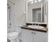 Bathroom with modern white vanity, dark countertops, toilet, white shower tiles and chrome fixtures at 1050 Starkey Rd # 704, Largo, FL 33771