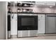 Close-up of a modern stainless steel oven, next to white cabinets and gray countertops at 1050 Starkey Rd # 704, Largo, FL 33771