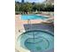 Community pool with a jacuzzi and lounge chairs on a sunny day, offering a relaxing and inviting atmosphere at 1050 Starkey Rd # 704, Largo, FL 33771