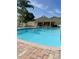 Community pool with brick patio and clubhouse in the background at 1050 Starkey Rd # 704, Largo, FL 33771