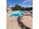 Community pool surrounded by brick patio and lush tropical landscaping at 1050 Starkey Rd # 704, Largo, FL 33771