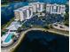 Stunning aerial view of condo buildings, pool, parking, and lakefront scenery, showcasing the community's amenities at 10520 Boardwalk Loop # 202, Bradenton, FL 34202