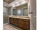 Spacious bathroom boasts a double sink vanity with a granite countertop, large mirror, and a glass-enclosed shower stall at 10520 Boardwalk Loop # 202, Bradenton, FL 34202