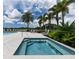Community hot tub bordered by lush vegetation with swaying palm trees under a bright sunny sky at 10520 Boardwalk Loop # 202, Bradenton, FL 34202