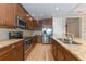 Modern kitchen with stainless steel appliances, granite countertops, and wood cabinetry, offering a gourmet experience at 10520 Boardwalk Loop # 202, Bradenton, FL 34202