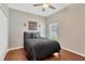 Bedroom with dark wood floor, neutral walls, ceiling fan, and queen bed with black comforter at 11153 Biddeford Pl, New Port Richey, FL 34654