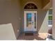 Close-up of the front door showcasing its glass design and sidelights, complemented by a neutral exterior paint color at 11153 Biddeford Pl, New Port Richey, FL 34654