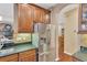 Kitchen featuring stainless steel refrigerator, dark cabinets, and tile backsplash at 11153 Biddeford Pl, New Port Richey, FL 34654