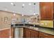 Open kitchen featuring a breakfast bar with granite counters and modern stainless steel dishwasher at 11153 Biddeford Pl, New Port Richey, FL 34654