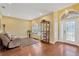 Bright living room with hardwood floors, decorative display cabinet, and a cozy seating area near the front door at 11153 Biddeford Pl, New Port Richey, FL 34654