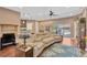 Open-concept living space with hardwood floors, a large sectional sofa, and a view of the outdoor pool area at 11153 Biddeford Pl, New Port Richey, FL 34654