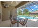 Relaxing covered patio with a table and chairs overlooking a sparkling pool and landscaped yard at 11153 Biddeford Pl, New Port Richey, FL 34654