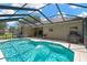 Sparkling pool inside screened enclosure surrounded by patio and a grill at 11153 Biddeford Pl, New Port Richey, FL 34654