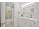 Well-lit bathroom featuring a tiled shower-tub, modern vanity with sink, and large mirror at 11799 Raintree Dr, Temple Terrace, FL 33617