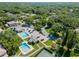 Aerial photo showcasing the community's sparkling pools, clubhouse, parking, and proximity to tennis courts at 11799 Raintree Dr, Temple Terrace, FL 33617