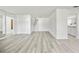Open concept living room featuring sleek laminate flooring and access to the bathroom, stairs, and kitchen at 11799 Raintree Dr, Temple Terrace, FL 33617
