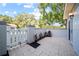Back patio with a private outdoor space, plants, and a white picket fence at 11799 Raintree Dr, Temple Terrace, FL 33617