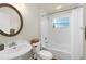 Bright bathroom with a round mirror, pedestal sink, and shower-tub combo at 12031 Mountbatten Dr, Tampa, FL 33626
