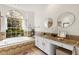 Bright bathroom boasts a soaking tub, large window, and dual vanity with granite countertops at 12031 Mountbatten Dr, Tampa, FL 33626