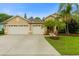 Charming home featuring a three-car garage, palm trees, and landscaped front yard at 12031 Mountbatten Dr, Tampa, FL 33626