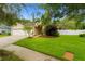 Beautiful one-story home with lush landscaping, a well manicured lawn and a white fence at 12031 Mountbatten Dr, Tampa, FL 33626