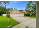 Inviting one-story home boasts a three-car garage, lush landscaping, and a well-manicured lawn at 12031 Mountbatten Dr, Tampa, FL 33626