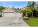 Charming one-story home with a three-car garage, mature palms, and lush landscaping at 12031 Mountbatten Dr, Tampa, FL 33626