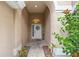 Welcoming front entry features a decorative door with sidelight, tiled walkway, and blossoming flowers at 12031 Mountbatten Dr, Tampa, FL 33626