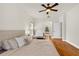 Bright bedroom with hardwood floors, a ceiling fan, and a comfortable seating area near the window at 12031 Mountbatten Dr, Tampa, FL 33626