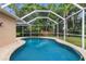 Inviting screened-in pool with clear blue water and surrounding green landscaping at 12031 Mountbatten Dr, Tampa, FL 33626