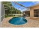 Inviting screened-in pool with brick patio and lounge area, perfect for relaxing and entertaining outdoors at 12031 Mountbatten Dr, Tampa, FL 33626
