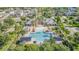 An aerial view of a community pool with a sandy beach and covered seating areas at 13194 Royal Pines Ave, Riverview, FL 33579