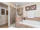Well-lit bathroom includes a glass enclosed shower and soaking tub at 13194 Royal Pines Ave, Riverview, FL 33579