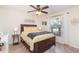 Cozy bedroom features a ceiling fan, decorative headboard, and natural light from a window at 13194 Royal Pines Ave, Riverview, FL 33579